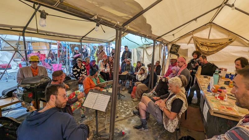 The tent packed with listeners on chairs and on the ground, the bar running along one side and the players at the far end.
